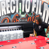 Custom DTF Gang Sheets | DTF Virginia printing process with a woman operating the printer.