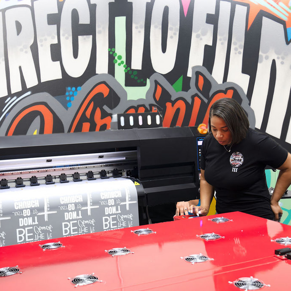 Custom DTF Gang Sheets | DTF Virginia printing process with a woman operating the printer.