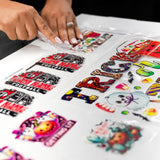 A person peeling UV DTF stickers from a sheet, showcasing vibrant designs for customizing tumblers.
