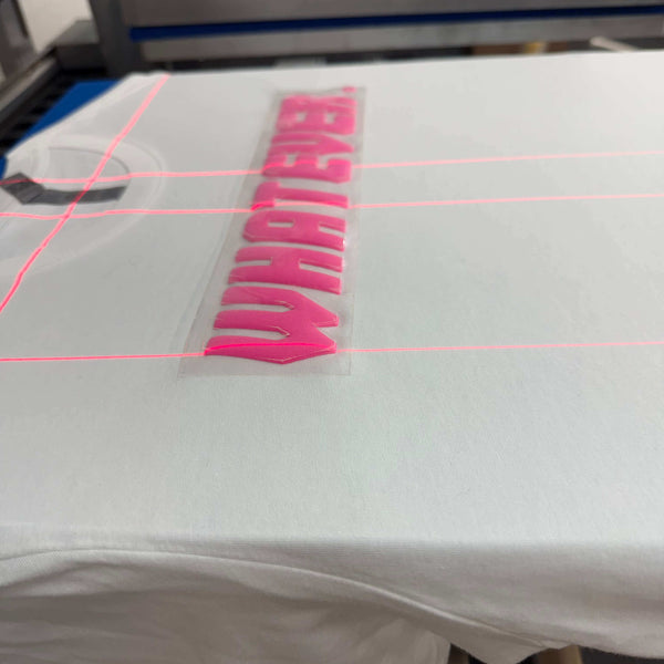 3D puff transfers in pink being applied to a white t-shirt using a heat press machine.