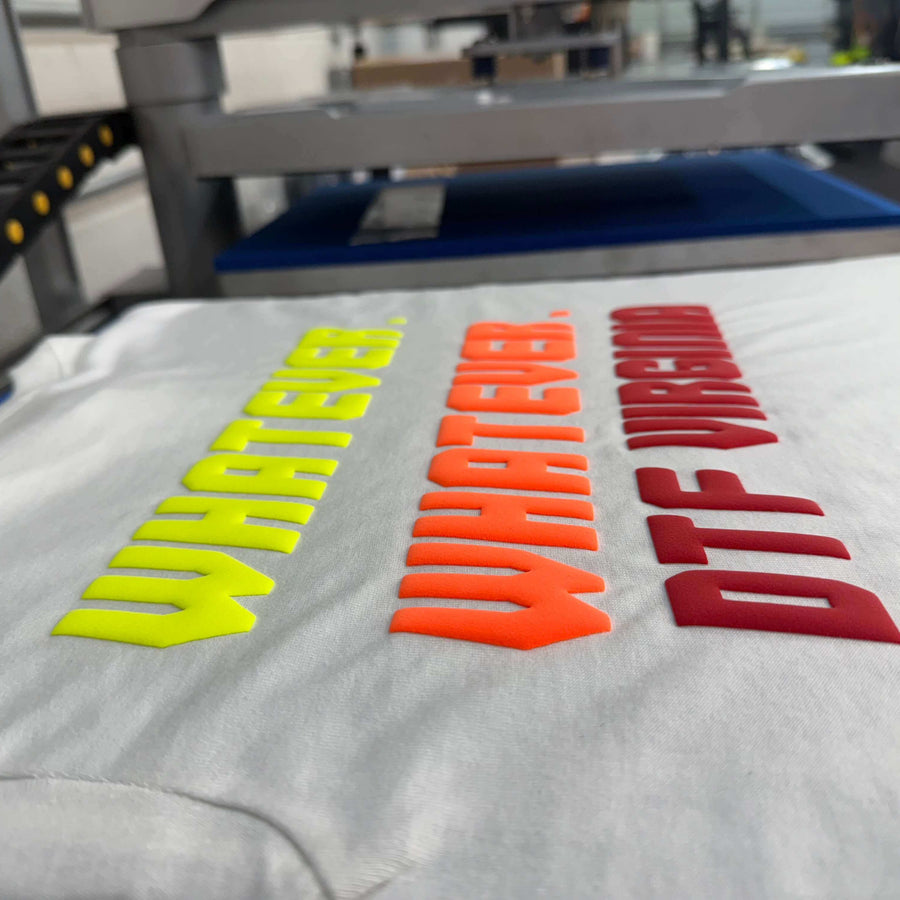 Close-up of 3D puff transfers on a white shirt showing colorful designs in yellow and red.