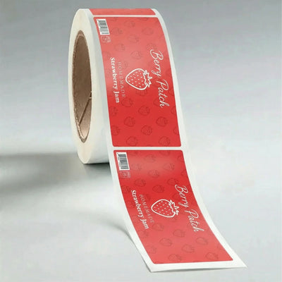 Roll of red labels with 'Berry Patch' branding on a gray background