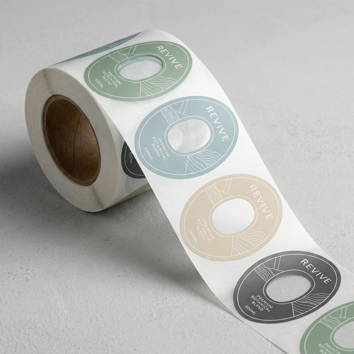 Roll of round stickers with 'REVIVE' branding on a light gray background