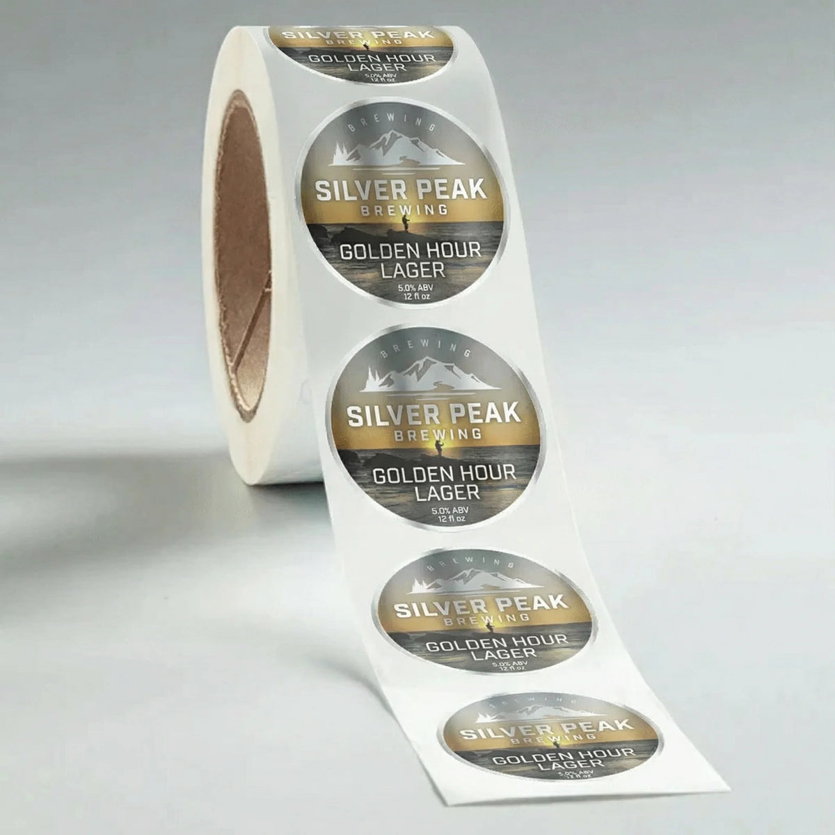 Roll of Silver Peak Brewing Golden Hour Lager labels on a gray background