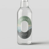 Clear glass bottle with a 'Revive' label on a light gray background