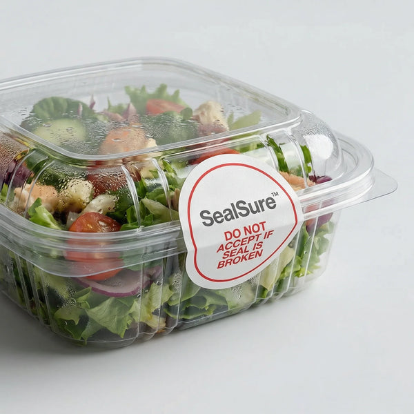 Salad in a clear container with a SealSure label on a light gray background