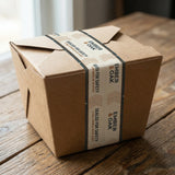 Cardboard box with Ember & Oak packaging on a wooden surface