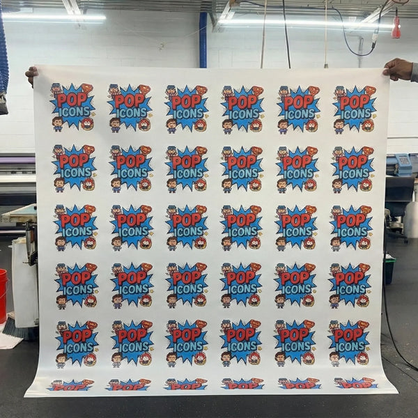 Sheet of paper with 'Pop Icons' logo and branding in a printing facility.